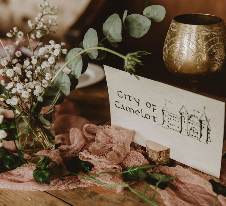 Table name cards made on card with medieval font and msall picture on tree trunk paper holders