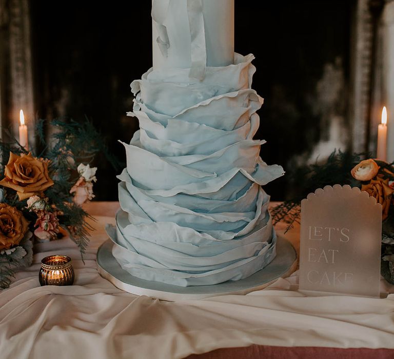 Blue wedding cake with ribbon and fabric texture detail