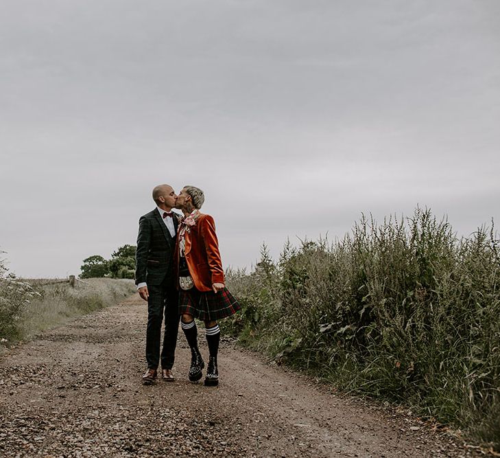 Grooms kiss in the road on their wedding day outdoors 