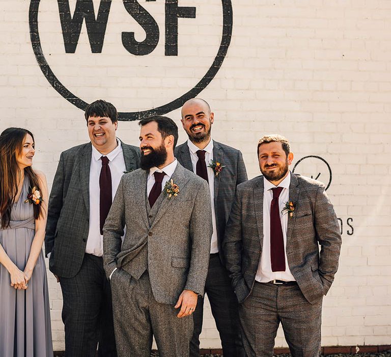 Groom with groomsmen and groomwoman all wearing grey for the industrial style wedding 