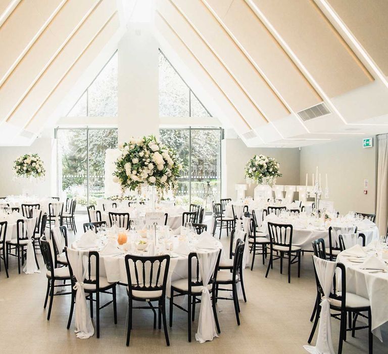 Elegant styled reception room finished with light up letters, candles to the middle of tables and large floral arrangements 