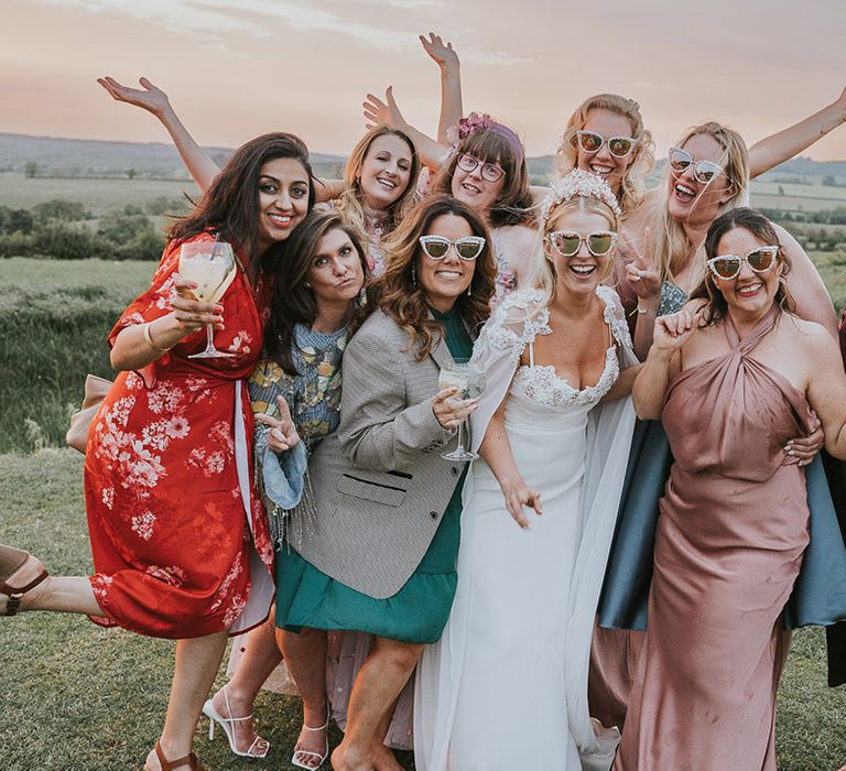 Bride wearing cool sunglasses with the bridesmaids and other wedding guests 