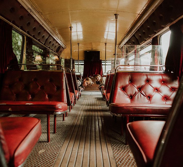 London Ghost Bus transport complete with red leather seats as flower girl and page boy pop out their heads from behind the seats 