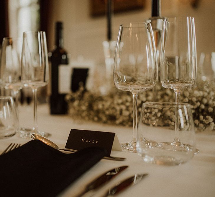 Black napkins complete with black name cards with white writing for gothic wedding reception tablescape