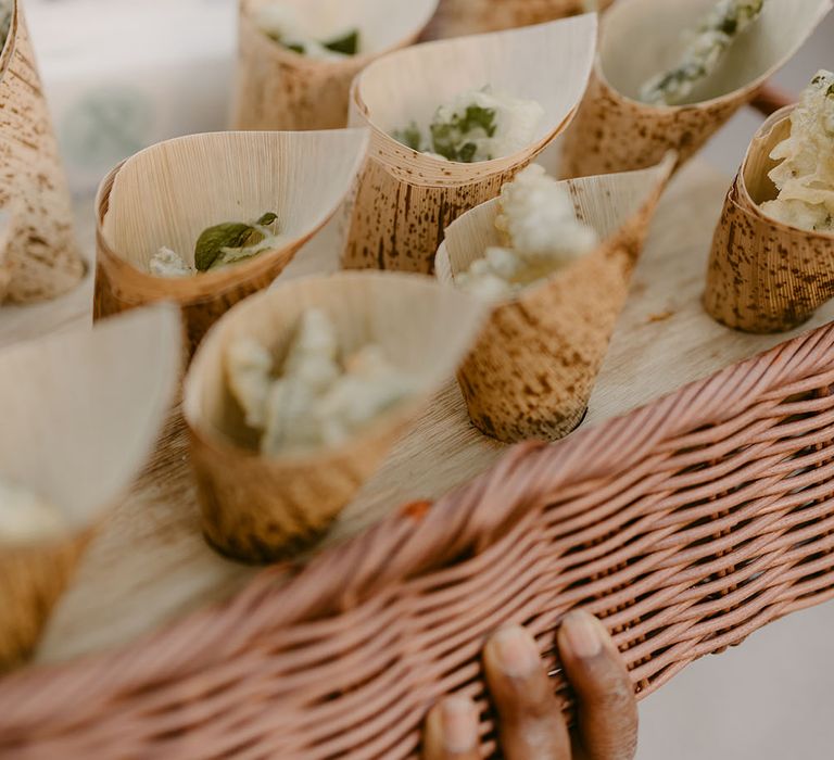 Dried confetti in paper cones in wicker basket 