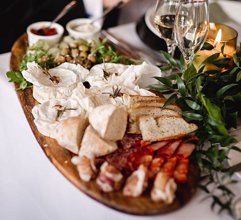 Colourful food on wooden board complete with cheese and olives 