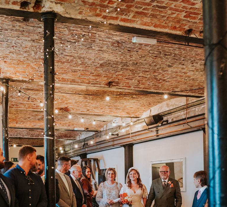 Bride being walked down the aisle with her mother and father at The Wool Tower wedding venue 