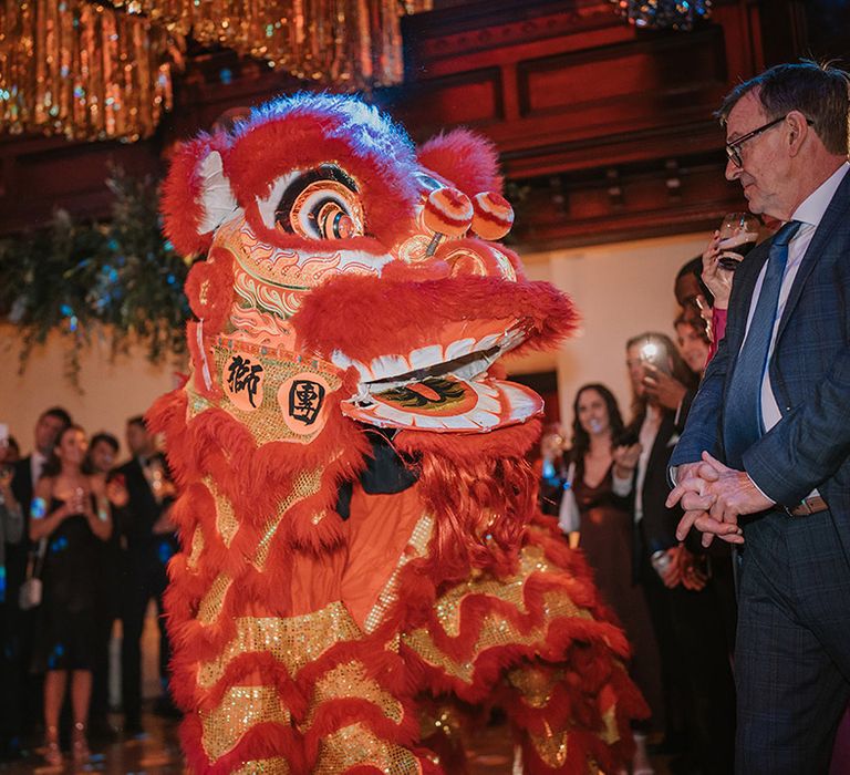 Close-up of traditional Chinese Lion Dance at multicultural Christmas wedding at Old Marylebone Town Hall, London 