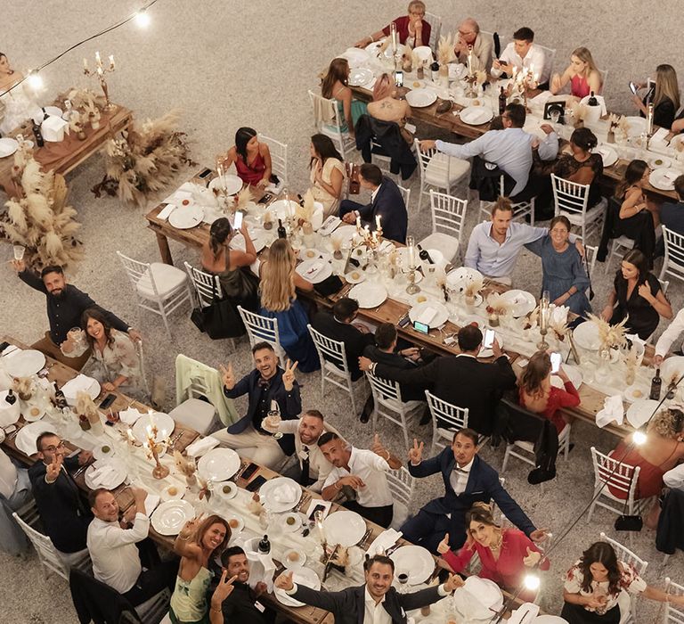 Wooden banquet tables complete with festoon lighting for outdoor wedding reception in Italy 