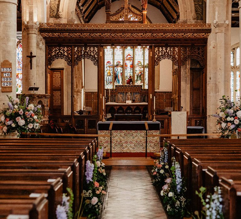 Traditional church wedding with pastel wildflower aisle decoration 