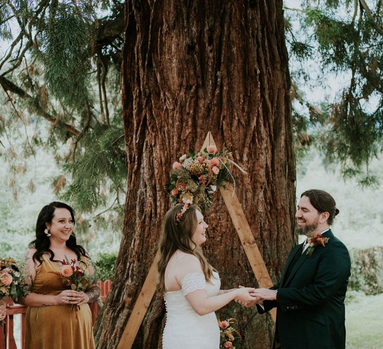 bride and groom exchanging wedding vows at their outdoor wedding ceremony 