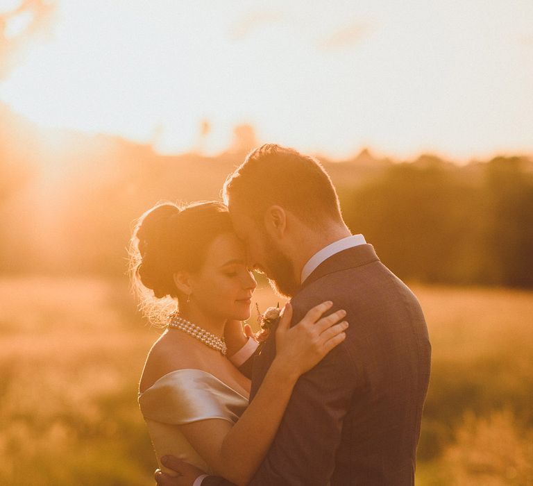 Golden hour portrait of bride and groom with the bride wearing a pearl choker necklace 