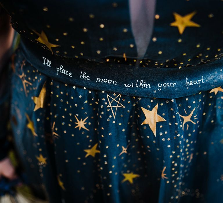 Bride in a navy blue wedding dress with gold stars and quotation from a movie 