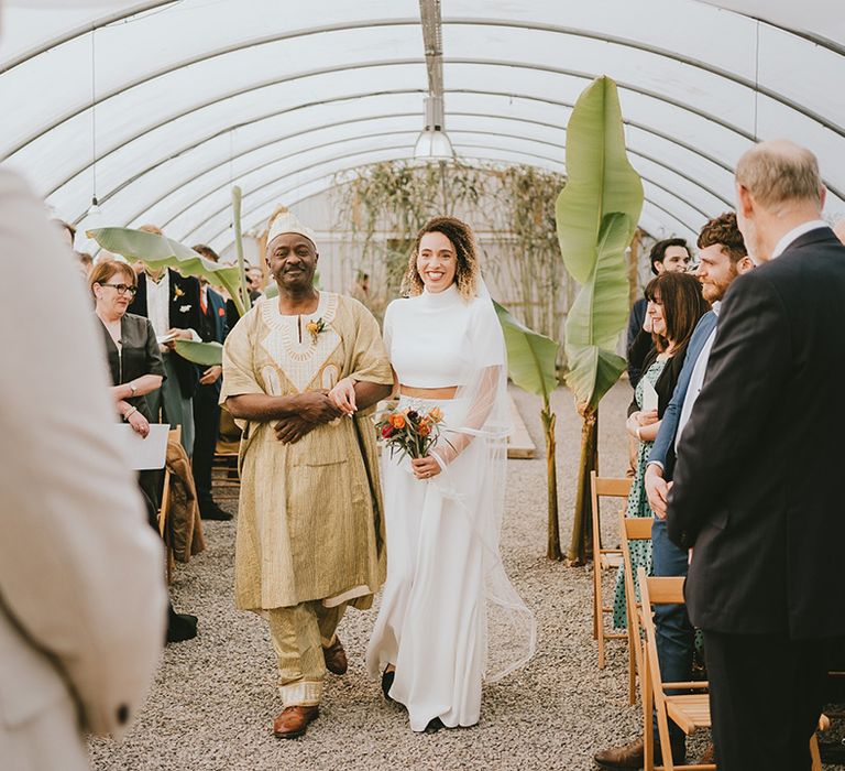 Father of the bride walks the bride down the aisle at the polytunnel greenhouse at Anran 