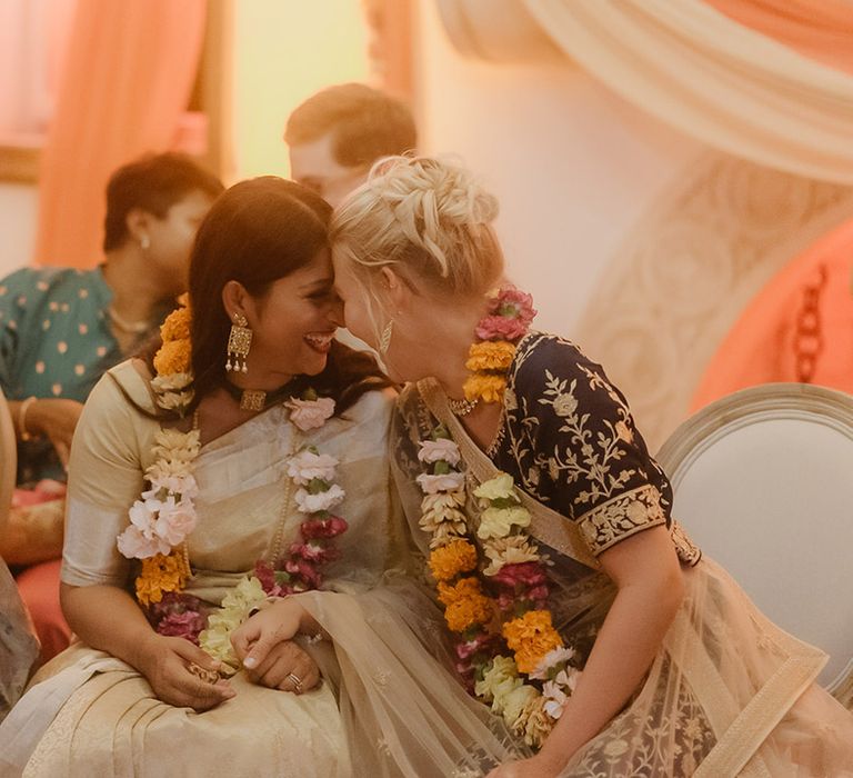 two brides in gold and navy Lehenga's at hindu wedding ceremony 