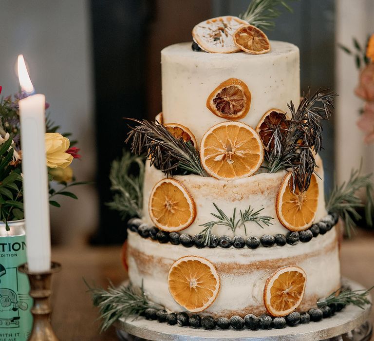 Three tier rustic wedding cake decorated with dried slices of orange 