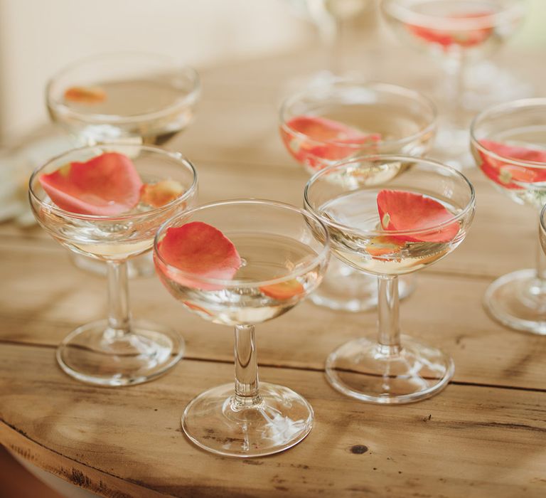 Rose petals in champagne coupe glasses from champagne tower 