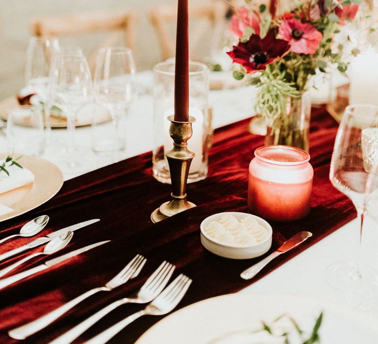 Christmas wedding tablescape with velvet red table runner and red wedding flowers and candles 