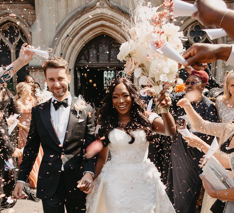 Confetti exit moment at church wedding ceremony for the bride and groom 