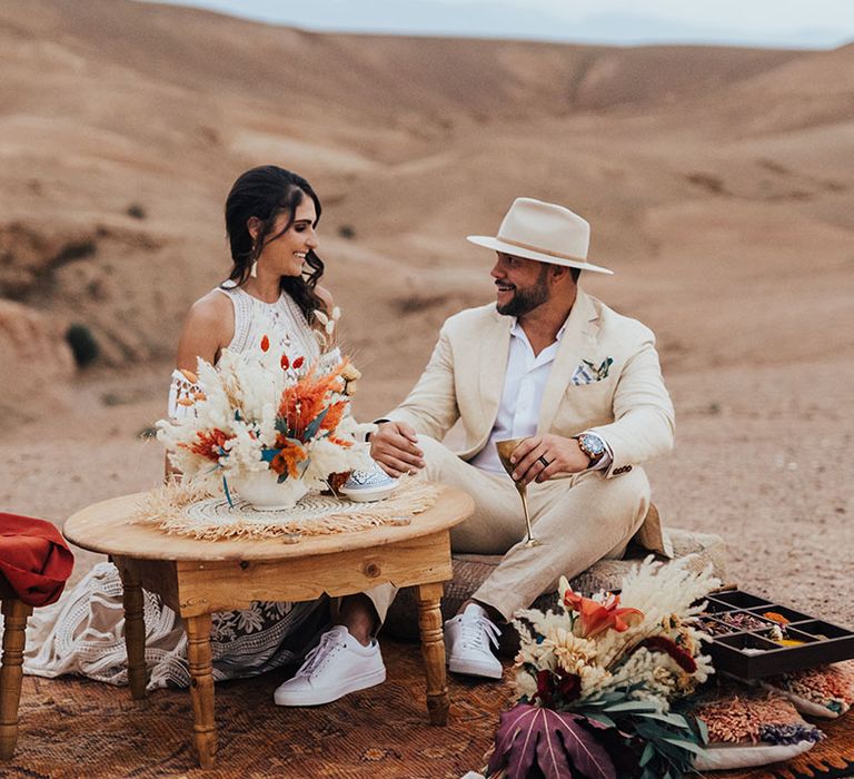 Intimate wedding breakfast between the bride and groom as they sit on the floor 