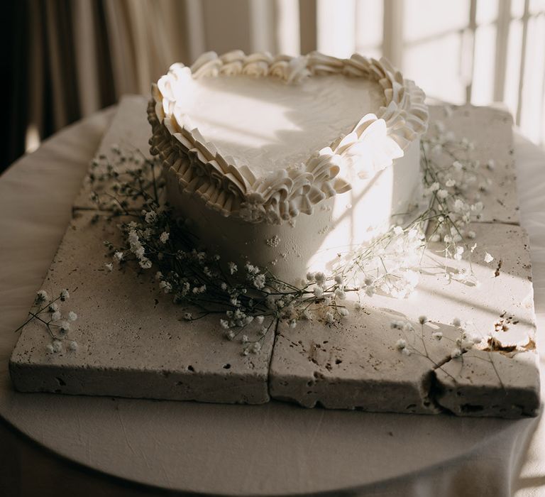 Traditional and classic white heart shaped wedding cake with plenty of frosting 