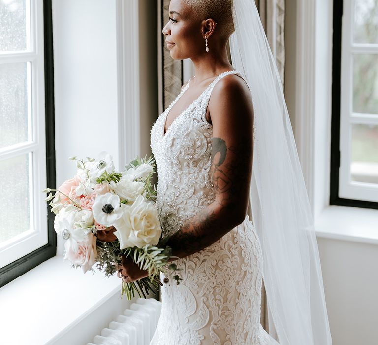 Bride in lace gown with veil and wedding bouquet 