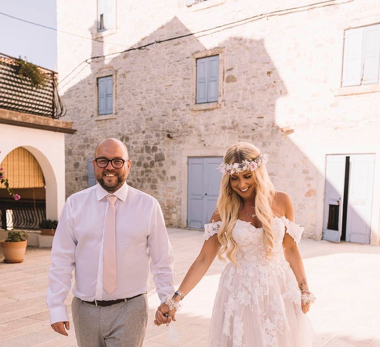 Groom wearing white shirt with pale pink tie with the bride in a boho off the shoulder gown 