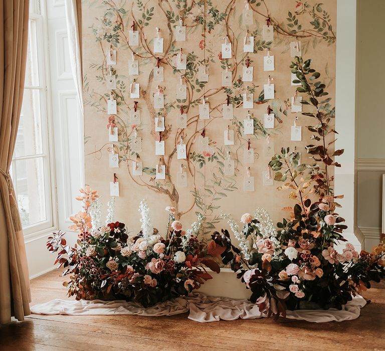 Tree wedding seating chart idea with autumnal flower arrangement 