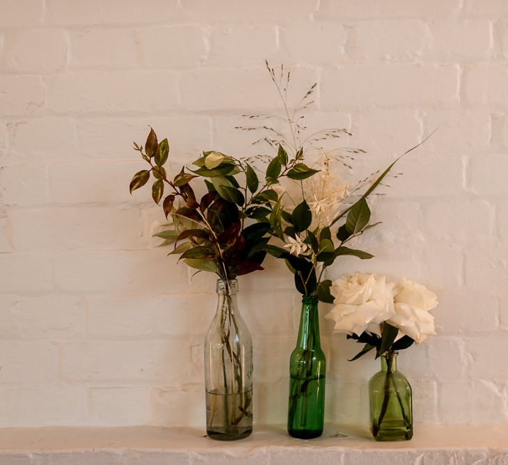 Wedding flowers and foliage in glass bottles