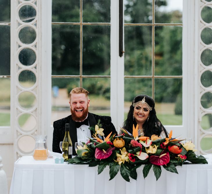 Sweetheart table with brightly coloured tropical plant floral decor