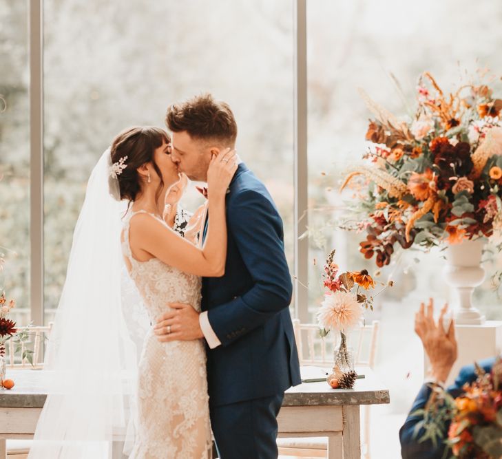 Bride and groom kissing at Millbridge Court wedding ceremony 