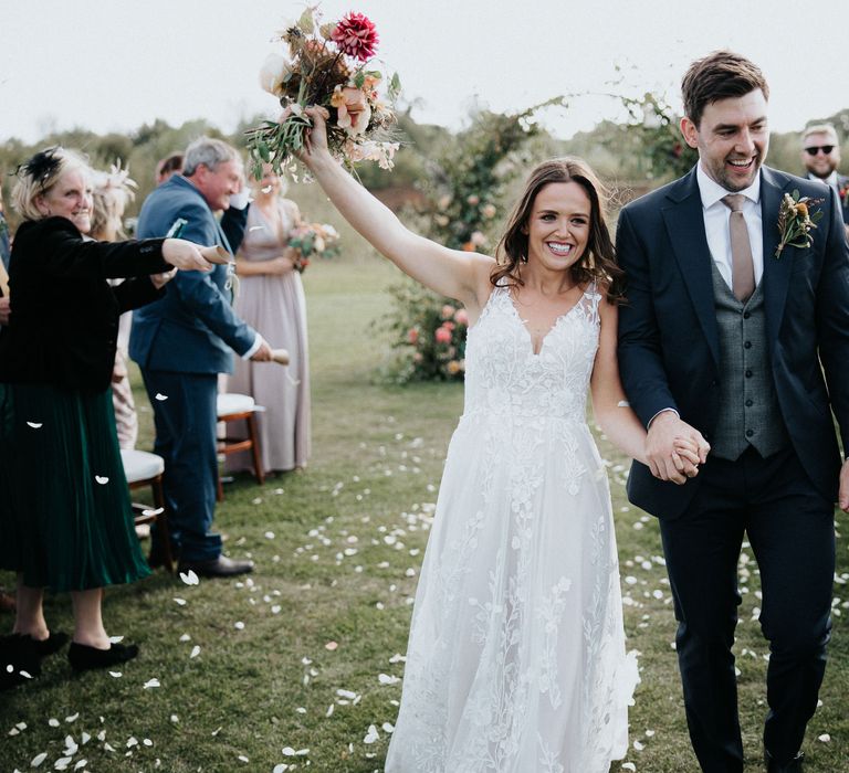 Bride and groom descending down the aisle as husband and wife 