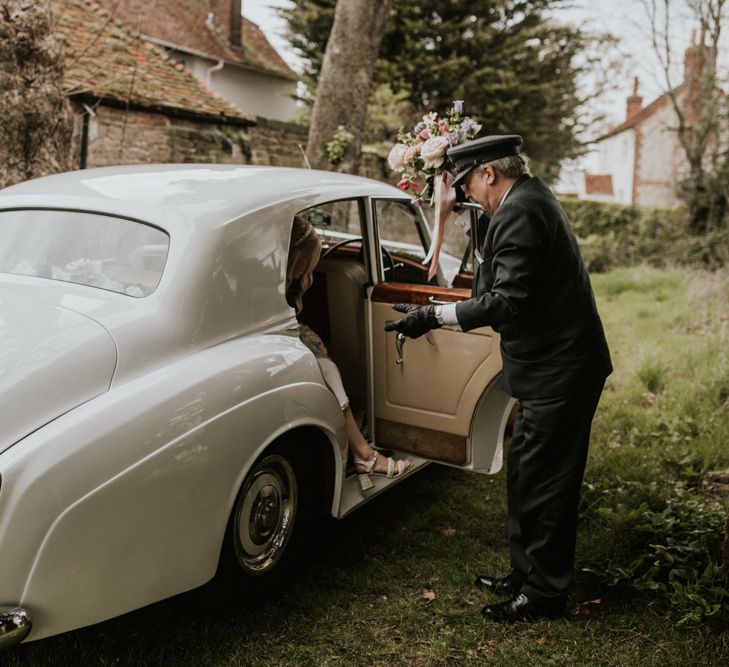 Bridal entrance in vintage white wedding car 