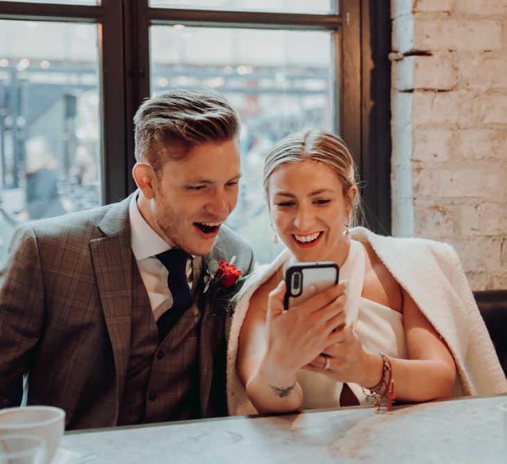 Bride and groom reading messages from guests who couldn't attend their micro wedding 