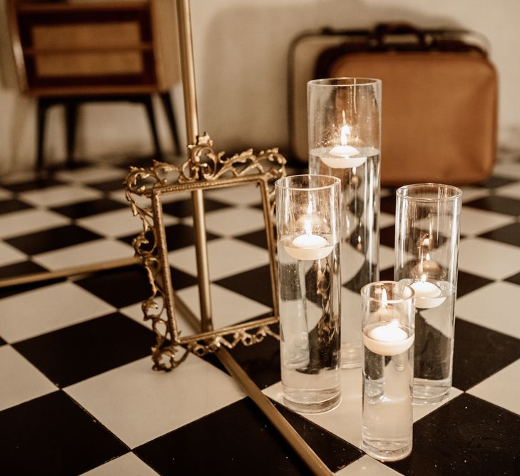 Suspended candles next to golden frame