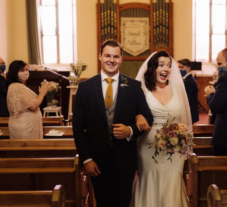 Bride & groom walk down aisle after marriage 