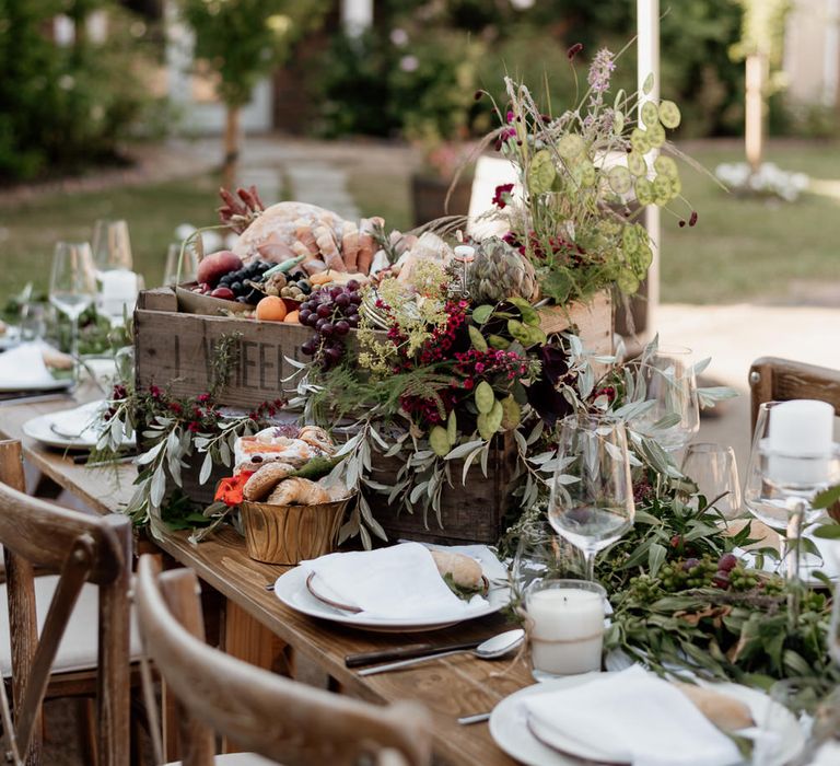 Grazing table box full of procured meats, fresh bread, fruits, nuts and foliage 