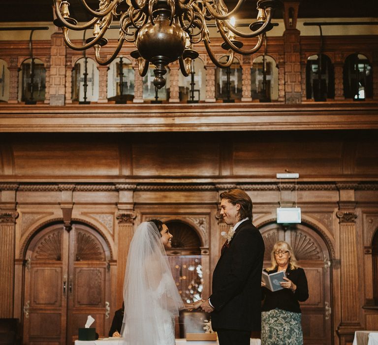 Bride and groom standing at the altar holding hands exchanging vows 