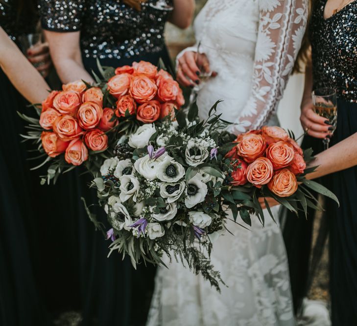 Bride and bridesmaids holding pink rose and white anemone wedding bouquets