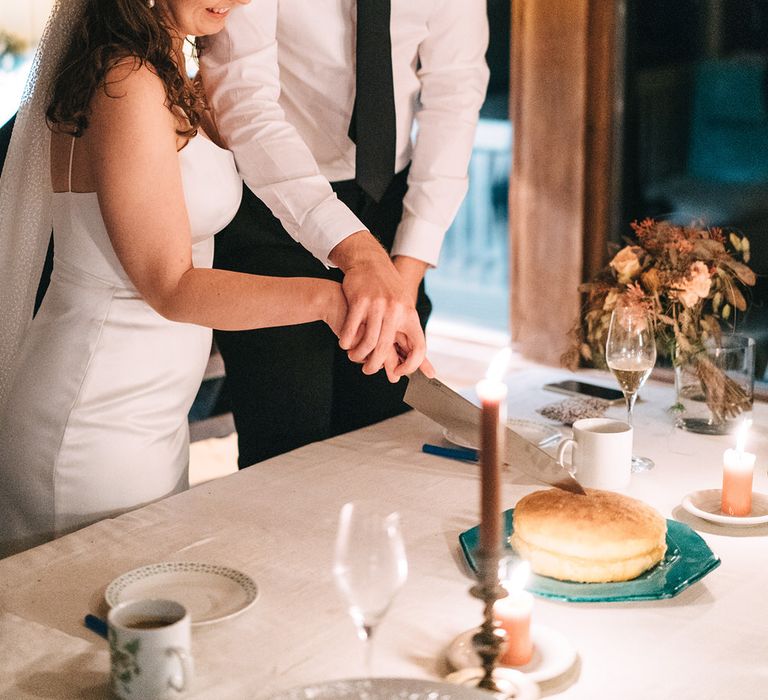 The bride and groom cut into a simple sponge cake together