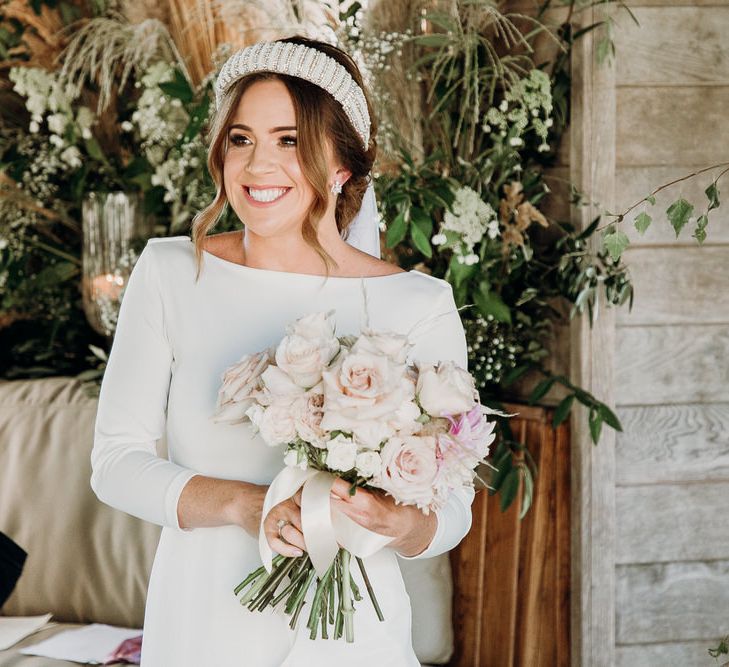 Smiling bride in Elbeth Gillis gown and beaded bridal headband holds blush pink rose wedding bouquet at Euridge Manor wedding