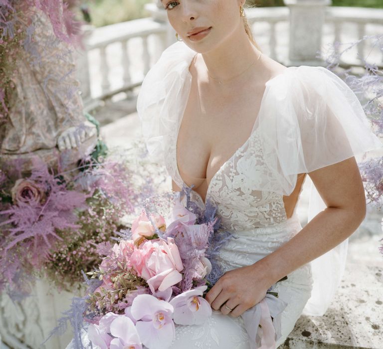 Bride looks at the camera in a lace gown