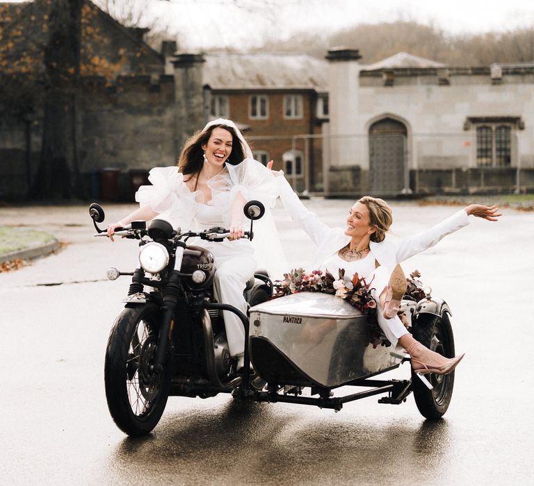 Tow bride riding a motorcycle with sidecar through the grounds of Ashridge House in Hertfordshire 