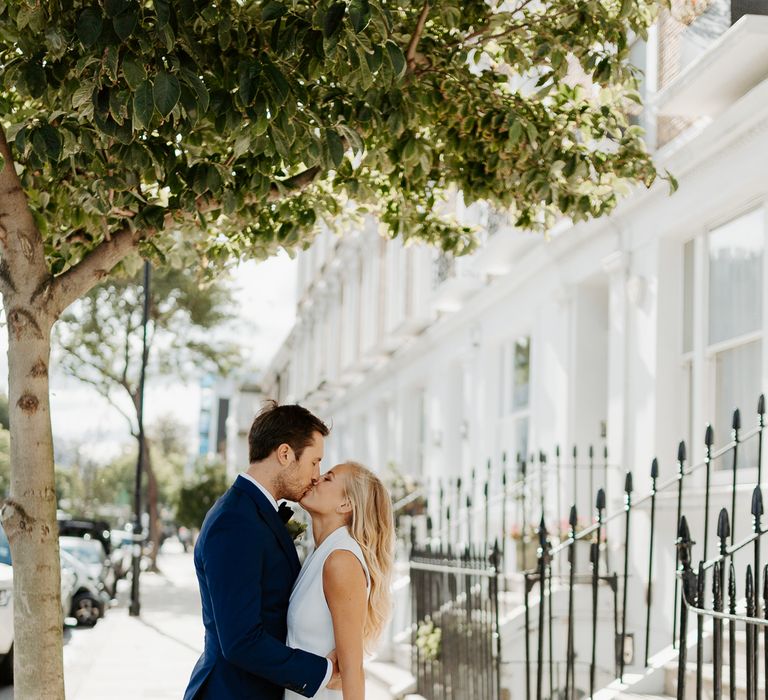 Bride & groom kiss in London with houses in the background