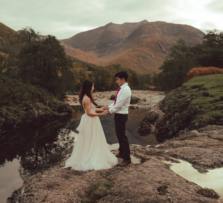 Couple stand with a lake in the background in Scotland