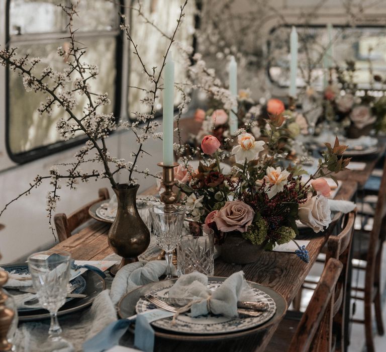 Rustic wooden table with floral decor and pale grey plates