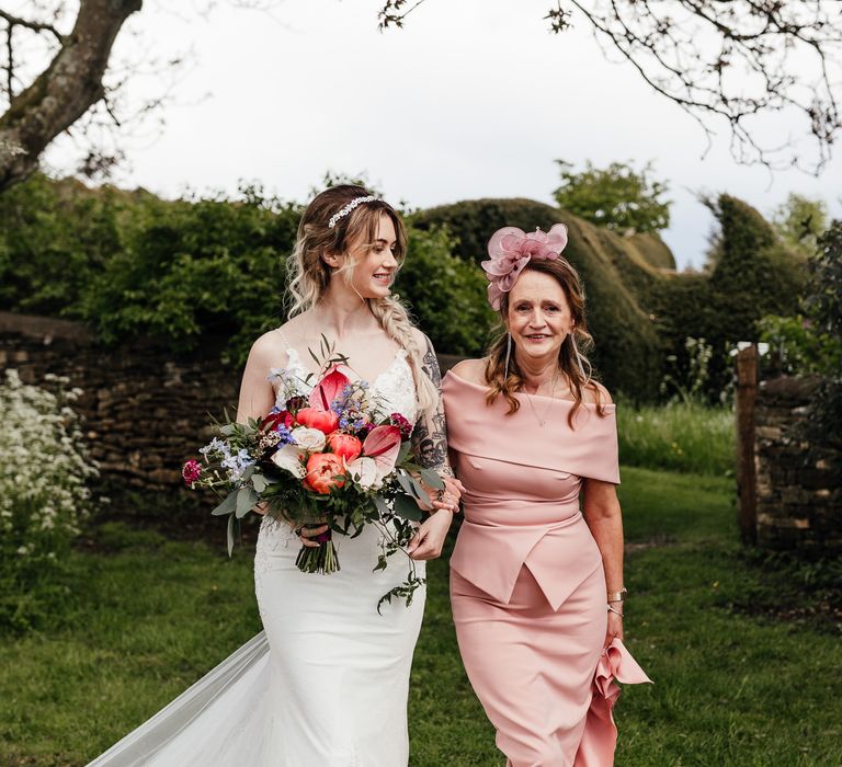 Bride walks with her mother down the aisle