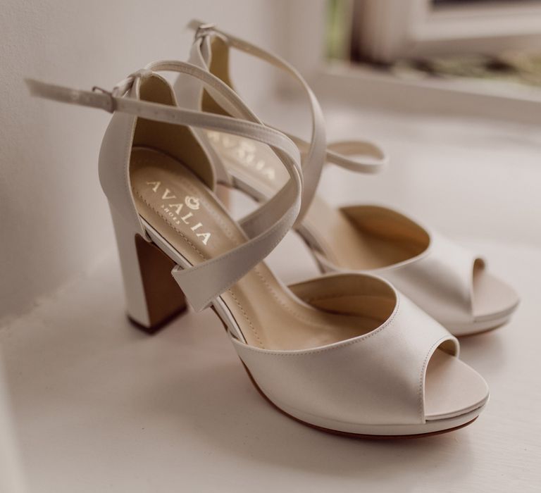 Pale grey Avalia block heels with cross straps on white windowsill before home farm wedding