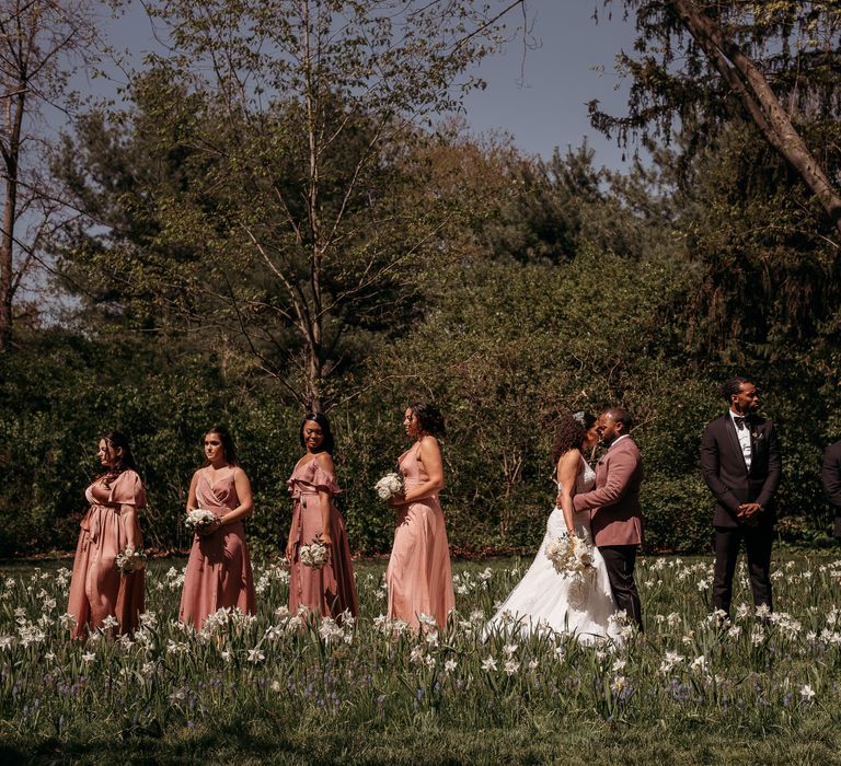 Bride & groom stand with their wedding party on the day of their wedding