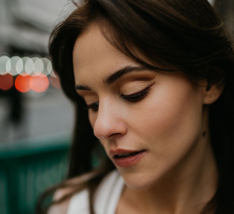 Wedding makeup for bride with brown hair with cream eyeshadow and winged eyeliner and light brown lipstick 